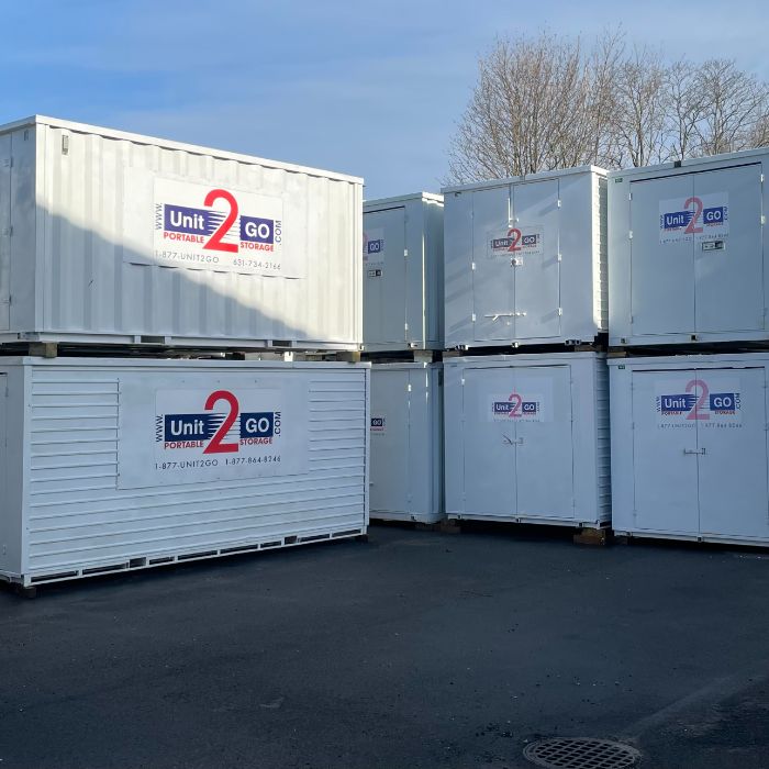 portable Unit2Go storage units stacked neatly on blacktop under a blue sky