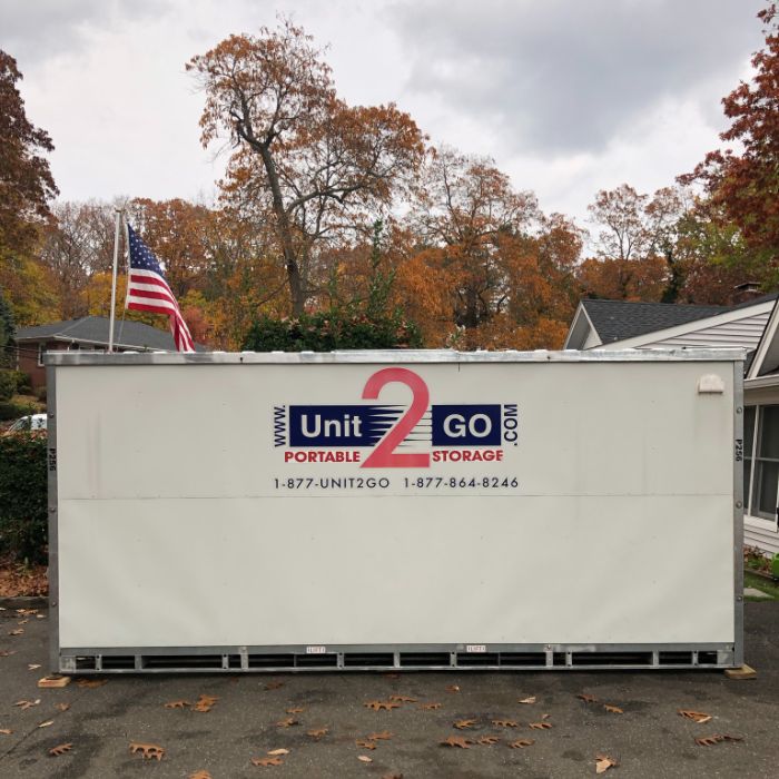 a Unit2Go portable storage container parked in a driveway of a home