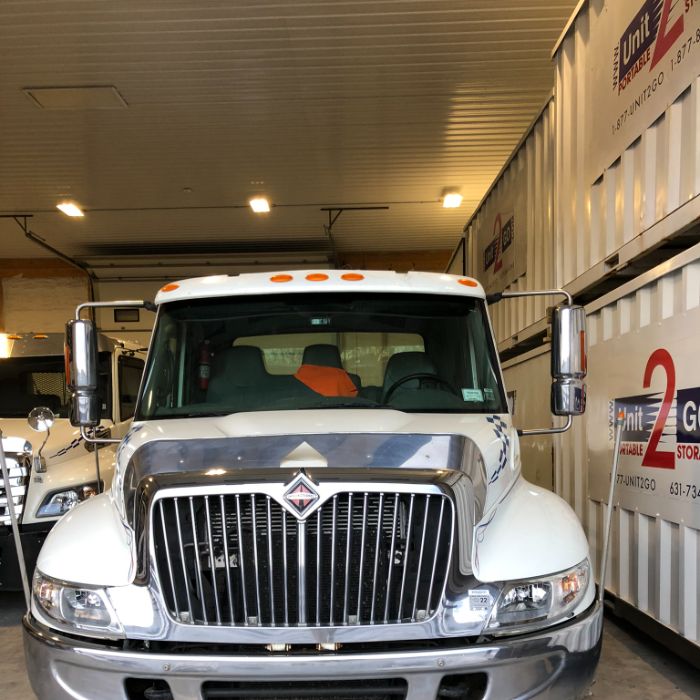 a Unit2Go portable container delivery truck parked in a portable storage unit warehouse