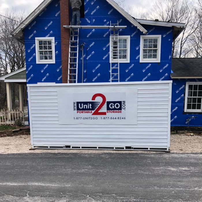 a Unit2Go portable storage unit in front of a home undergoing a renovation